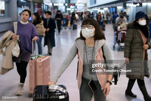 Passengers wearing masks arrive at Narita airport on January 24, 2020 in Narita, Japan. While Japan is one of the most popular foreign travel...