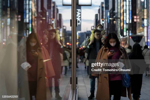 Chinese tourists wearing masks walk through the Ginza shopping district on January 24, 2020 in Tokyo, Japan. While Japan is one of the most popular...