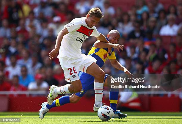 Clement Chantome of Paris St Germain is tackled by Clemente Rodriguez of Boca Juniors during the Emirates Cup match between Boca Juniors and Paris St...