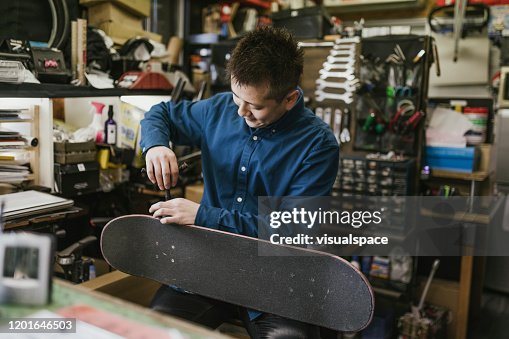 Skate Shop Owner Repairing a Skateboard Skate Shop Owner Repairing a Skateboard