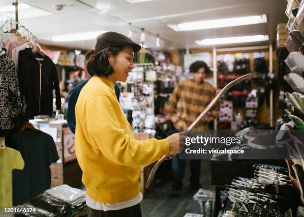 young man choosing a skateboard - sports merchandise stock pictures, royalty-free photos & images