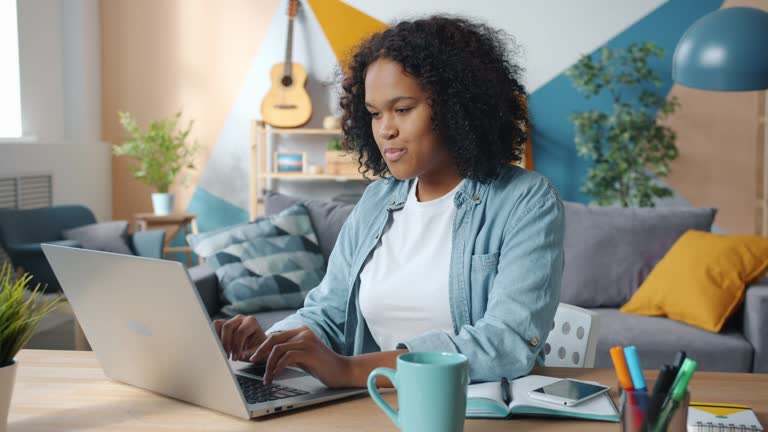https://media.gettyimages.com/id/1201655907/video/slow-motion-of-african-american-girl-using-laptop-in-apartment-smiling-typing-indoors.jpg?b=1&s=640x640&k=20&c=eIMzKoftU2gL_OM8vT7aDhTsKcamb4319nL8zJBBAOU=