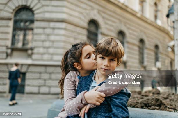 sister kisses brother on head - boy girl kissing stock pictures, royalty-free photos & images