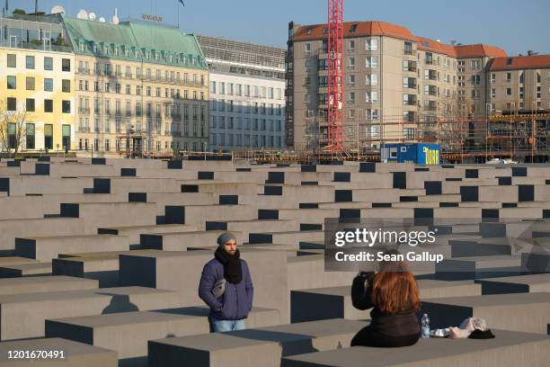 Visitors snap a photo among stellae at the Memorial to the Murdered Jews of Europe, which commemorates Jews murdered by the Nazis in the Holocaust,...