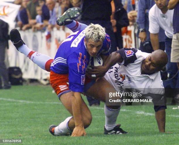 Le Berjallien Tuni Eremodo tente d'intercepter le Parisien Raphäel Poulain, le 16 septembre 2000 au stade Pierre-Rajon à Bourgoin-Jallieu, lors du...