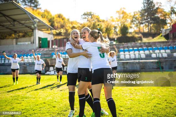 excited female soccer team celebrating goal on the field - soccer team stock pictures, royalty-free photos & images