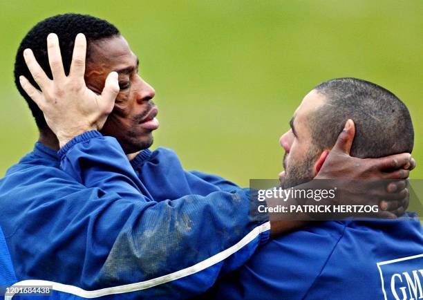 Le troisième ligne aile de l'équipe de France de rugby Serge Betsen effectue son échauffement avec son coéquipier Jean-Baptiste Rué, le 12 février...