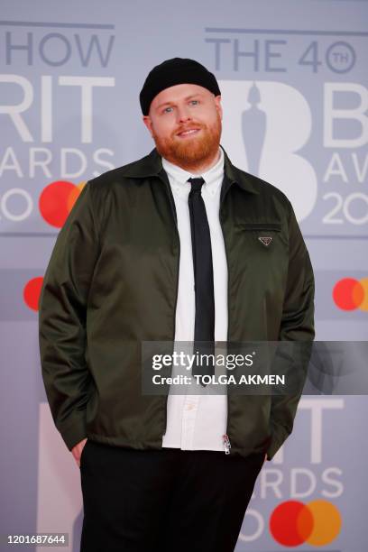 British singer-songerwriter Tom Walker poses on the red carpet on arrival for the BRIT Awards 2020 in London on February 18, 2020. / RESTRICTED TO...