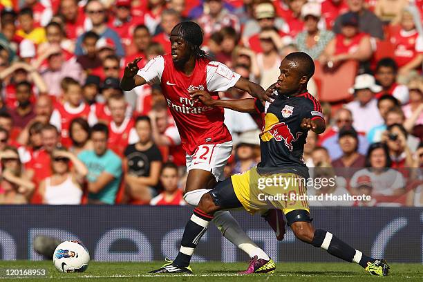 Gervinho of Arsenal holds off the challenge by Dane Richards of New York Red Bulls during the Emirates Cup match between Arsenal and New York Red...