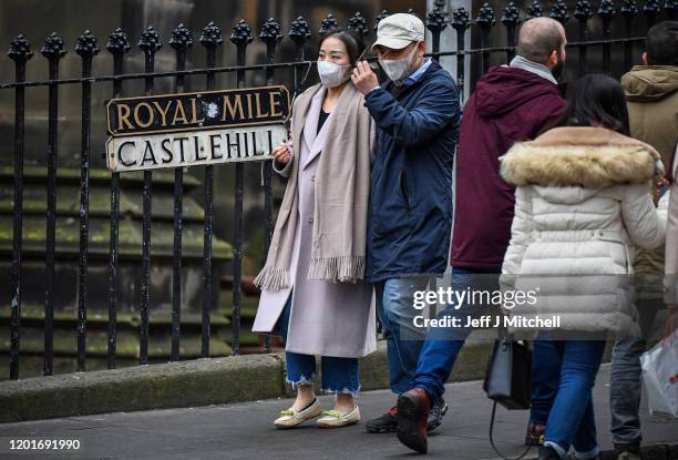 Tourists wear face masks as they visit Edinburgh Castle on January 24, 2020 in Edinburgh, Scotland. It has been confirmed that 14 people in Scotland...