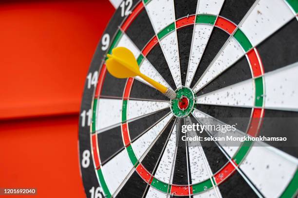 dart arrow hitting in the target center of dartboard - cible de jeu de fléchettes photos et images de collection