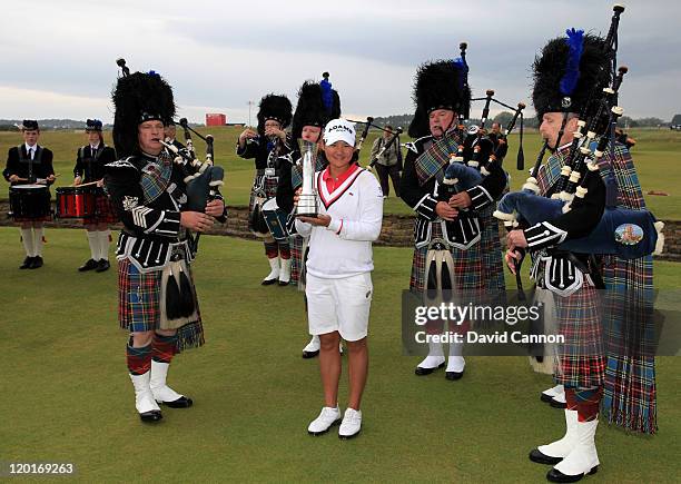 Yani Tseng of Taiwan poses with the trophy and bagpipers following her victory at the end of the final round of the 2011 Ricoh Women's British Open...