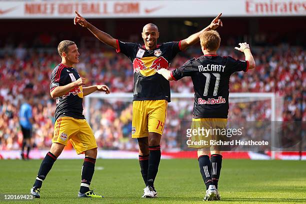 Thierry Henry of New York Red Bulls celebrates with team mates John Rooney and Dax McCarty after Kyle Bartley of Arsenal scores an own goal during...