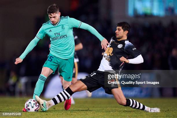 Jose Angel of Unionistas CF competes for the ball with Federico Valverde of Real Madrid CF during the Copa del Rey round of 32 match between...