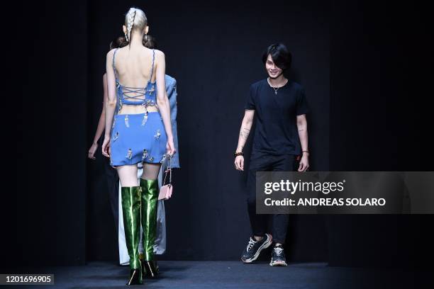 New York based Chinese designer Han Wen acknowledges applause following the presentation of the "China, We are With You" fashion show, kicking off...