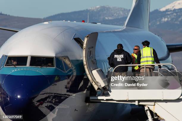 Agents working for U.S. Immigration and Customs Enforcement prepare to board detainees onto a Swift Air charter flight at McCormick Air Center on...