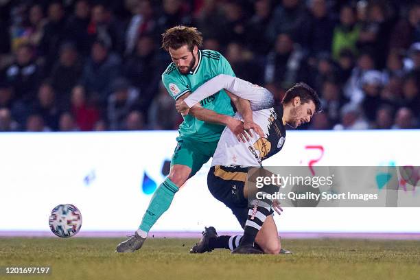 Carlos de la Nava of Unionistas CF competes for the ball with Nacho Fernandez of Real Madrid CF during the Copa del Rey round of 32 match between...