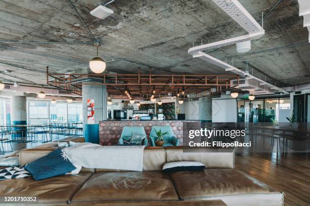 a luxury empty coworking studio with a shared bar counter and a relax area - design studio stock pictures, royalty-free photos & images