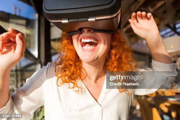 lockige rothaarige frau mit vr brille - vr goggles woman stock-fotos und bilder