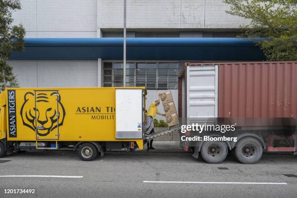 An Asia Tigers Group employee transfers boxes from a truck into a shipping container, during a customer's relocation overseas, in Hong Kong, China,...