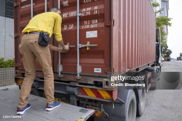 An Asia Tigers Group employee secures a shipping container, during a customer's relocation overseas, in Hong Kong, China, on Friday, Feb. 14, 2020....