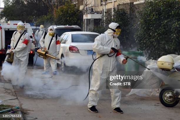 This photo taken on February 18, 2020 shows members of a police sanitation team spraying disinfectant in a street as a preventive measure against the...
