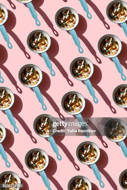top view of pan full of various pills and tablets on the blue background - meme personnage photos et images de collection