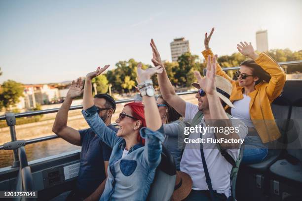 allegro gruppo di turisti con le braccia alzate godendo di un giro in autobus all'aperto - autobus a due piani foto e immagini stock