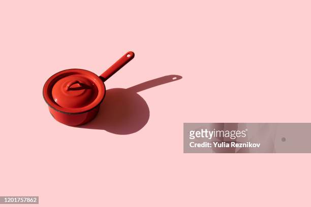 repeated old red kitchen pan on pink background - panela imagens e fotografias de stock