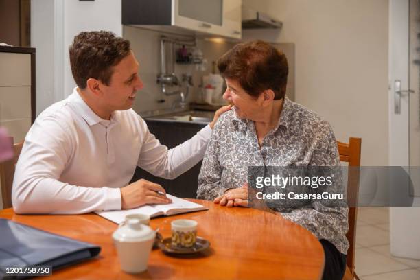 home caregiver giving emotion support to a senior woman at her home - emotional support stock pictures, royalty-free photos & images