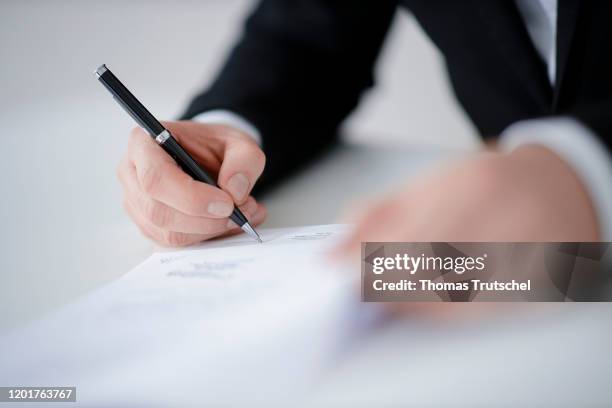 Symbol photo on the subject of contract conclusion. A man signs a contract with a pen on February 18, 2020 in Berlin, Germany.