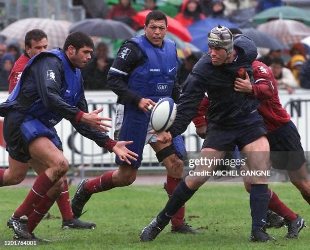 Le capitaine de l'équipe de France, Fabien Pelous , passe le ballon au 2ème ligne David Auradou sous les yeux d'Abdelatif Benazzi le 28 mars 2001 au...