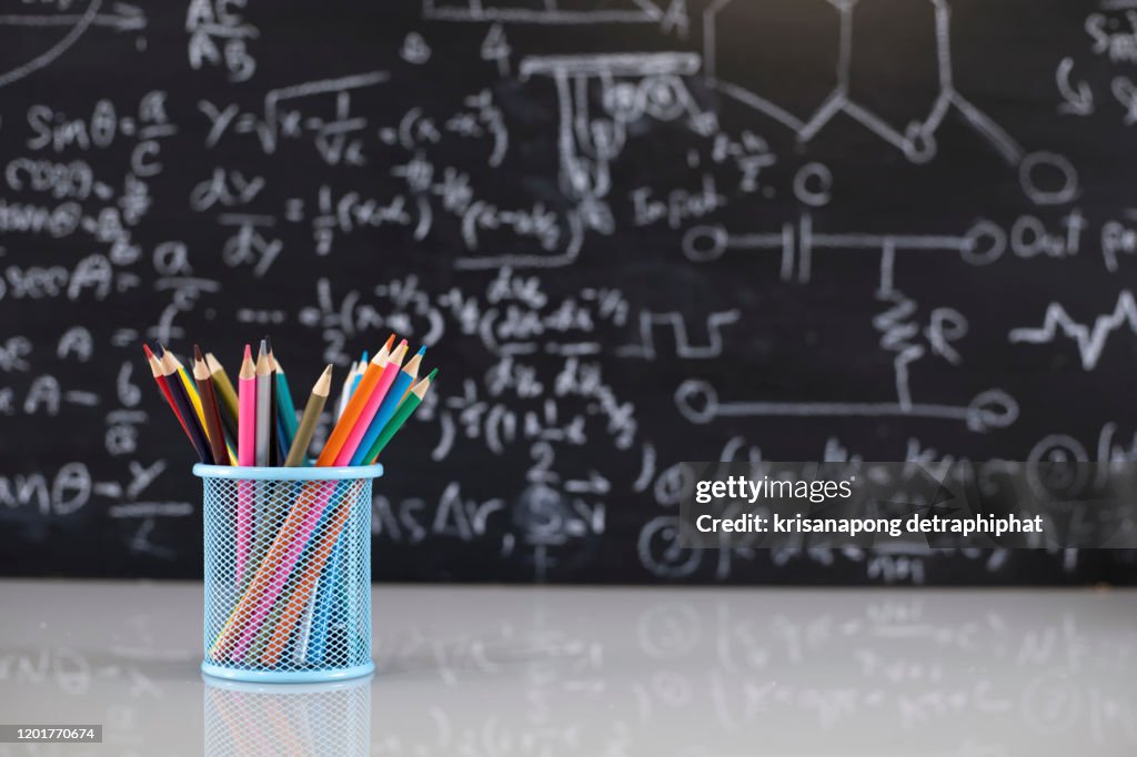 Colored pencils on the blackboard background
