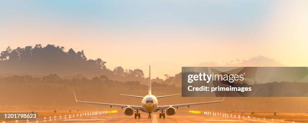 passagierjet vor landung am frühen morgen in asien flughafen - aircraft landing stock-fotos und bilder