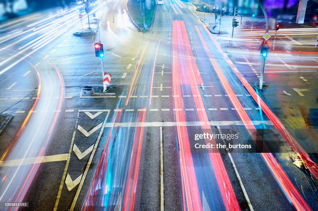 High angle view of crossroad and traffic lights with light trails of cars at night