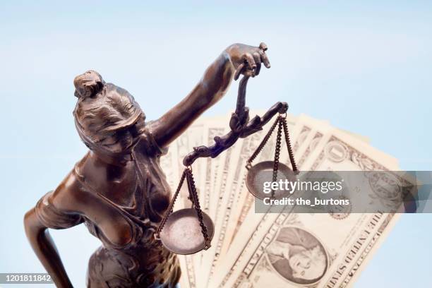 lady justice and american dollar banknotes against blue background - justitia-waage stock-fotos und bilder