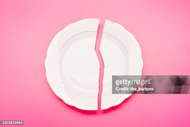 broken plate on pink background - assiette cassée photos et images de collection