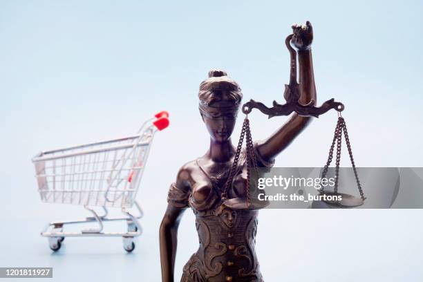 lady justice and shopping cart against blue background - lady justice technology stock pictures, royalty-free photos & images