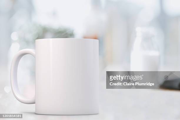 mug mockup. white coffee mug infant of a small bottle of milk. perfect for businesses selling mugs, just overlay your quote or design on to the image. - mug mockup stock pictures, royalty-free photos & images