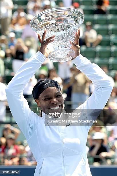 Serena Williams poses for photographers after her win over Marion Bartoli of France during the final of the Bank of the West Classic at the Taube...