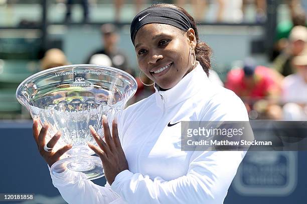 Serena Williams poses for photographers after her win over Marion Bartoli of France during the final of the Bank of the West Classic at the Taube...