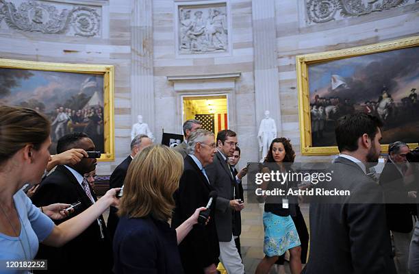 Senate Majority Leader Sen. Harry Reid tries to make his way through photographers and journalists while returning to his office after meeting with...