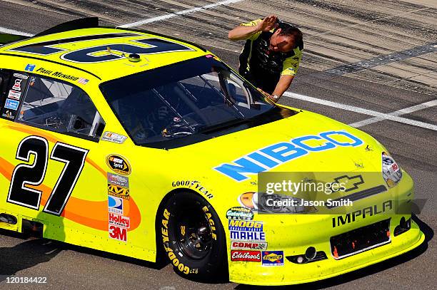 Crew members congratulate Paul Menard, driver of the NIBCO/Menards Chevrolet, after winning the NASCAR Sprint Cup Series Brickyard 400 at...