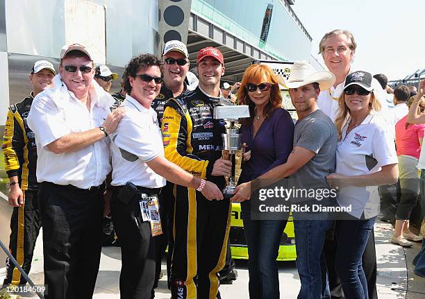 Brickyard 400 winner Paul Menard poses with team owner Richard Childress, CEO and President of Big Machine Records Scott Borchetta, winning team...