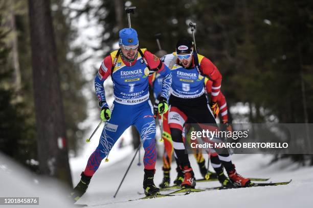 Russia's Alexander Loginov and Austria's Dominik Landertinger compete in the IBU Biathlon World Cup Men's 20km Individual competition in...