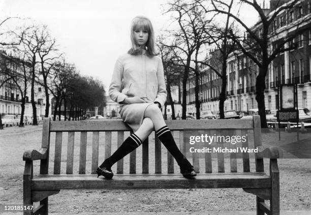 Model and photograher Pattie Boyd posing on a park bench, 1964. Boyd was married to George Harrison and Eric Claption.