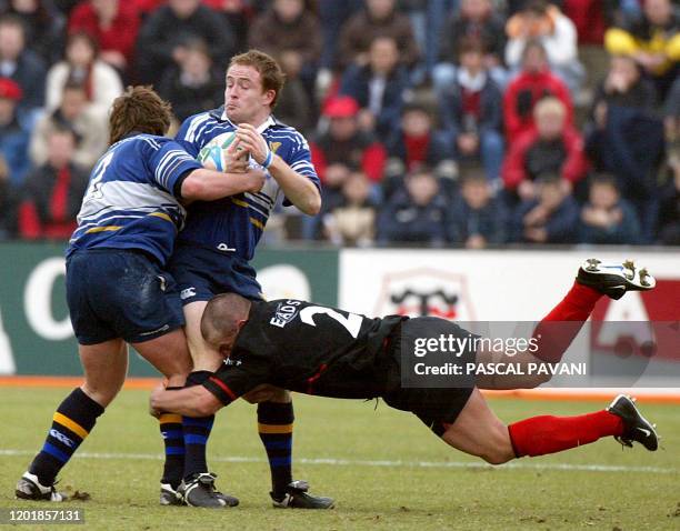 L'ailier irlandais de Leinster Shane Horgan protège son coéquipier, l'ailier Dennis Hickie malgré la charge du talonneur toulousain Yannick Bru, le...