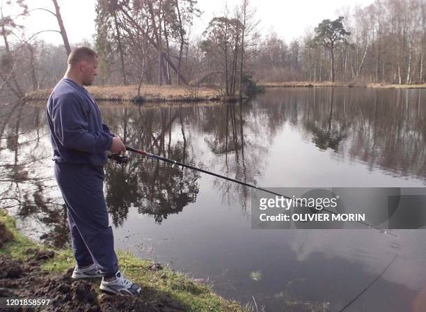 Le pilier international Christian Califano pêche dans l'étang du château de Clairefontaine, le 17 mars 2000, lors d'un stage d'entraînement du XV de...