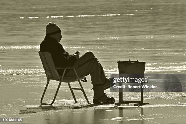 ice fishing with coal bucket and cell - heat wave elderly stock pictures, royalty-free photos & images