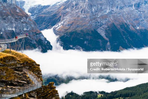 tourists on first cliff walk elevated walkway, grindelwald, switzerland - interlaken ストックフォトと画像